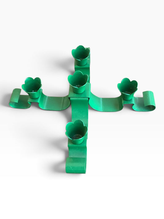 Gina’s Mercantile matte green metal candle holder with five flower-shaped cups in a cross-shaped centerpiece design.